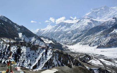 Scenic view of bhudist monastery in snowcapped mountains against sky