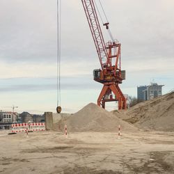 Cranes at construction site against sky