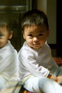 Portrait of cute boy sitting on floor