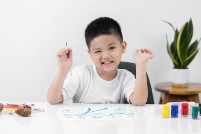 Portrait of cute boy holding table