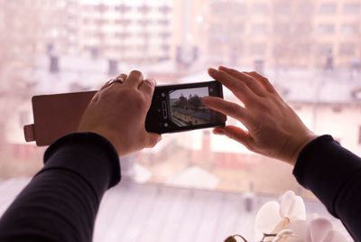 Midsection of man photographing with mobile phone