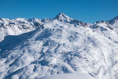 Scenic view of snowcapped mountains against clear blue sky