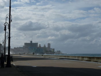 Sea by city buildings against sky