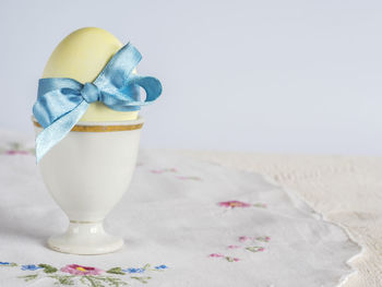 Close-up of blue tied bow ribbon on easter egg on table