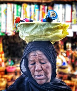 Close-up of woman carrying toys in basket on head