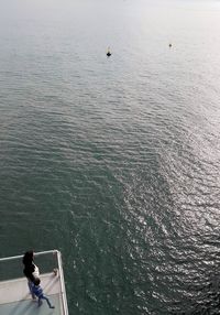 Mother and son standing at observation point against sea