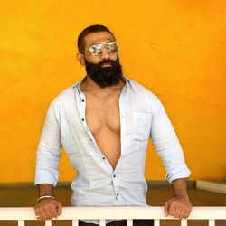 Portrait of young man standing against yellow wall