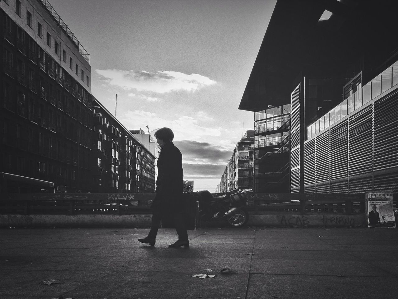 architecture, built structure, building exterior, full length, sky, lifestyles, walking, men, rear view, leisure activity, cloud - sky, person, city, standing, cloud, city life, street, silhouette