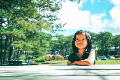 Portrait of a smiling young woman against road