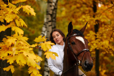 Portrait of woman riding horse on field