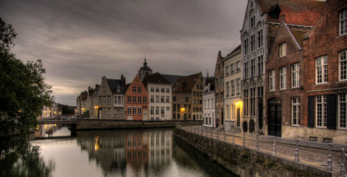 Canal amidst buildings against sky at dusk