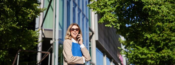 Low angle view of woman standing against trees