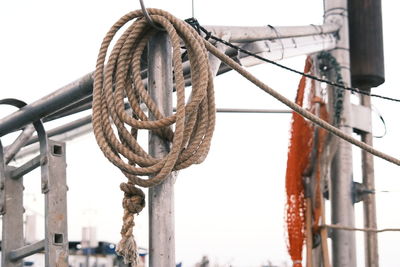 Close-up of rope tied to wooden post against sky
