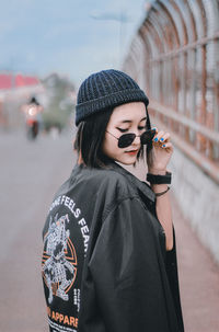 Portrait of young woman standing on street in city