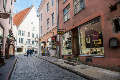 People walking on street amidst buildings in city