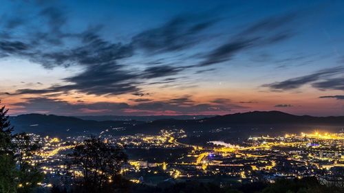 High angle view of illuminated cityscape against sky at sunset