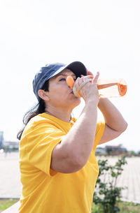 Midsection of man holding yellow while standing against sky