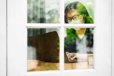 Woman looking through window