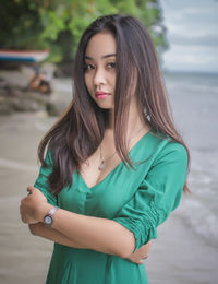 Portrait of young woman standing at beach