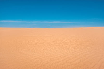 Scenic view of desert against blue sky