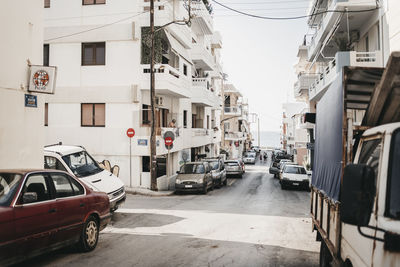 Cars parked on road by buildings in city