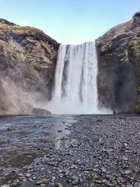 Scenic view of waterfall against sky