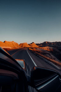 Car moving on road against clear sky