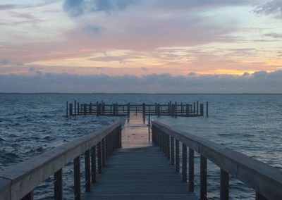 Pier on sea against sky during sunset