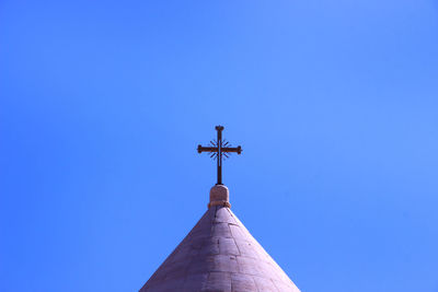 Low angle view of weather vane against clear blue sky