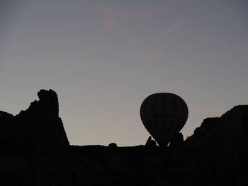 Low angle view of silhouette rocks against clear sky