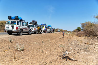 Panoramic view of truck on field against clear blue sky