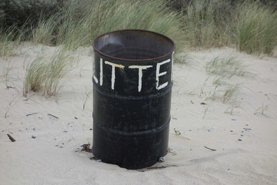 Close-up of garbage bin on field