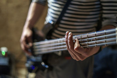 Midsection of young man playing guitar