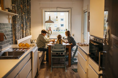 Mother and children sitting at kitchen table