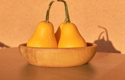 Close-up of orange juice on table against wall