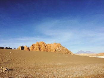 Scenic view of desert against blue sky