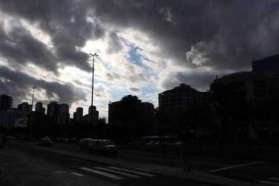 View of city street against cloudy sky