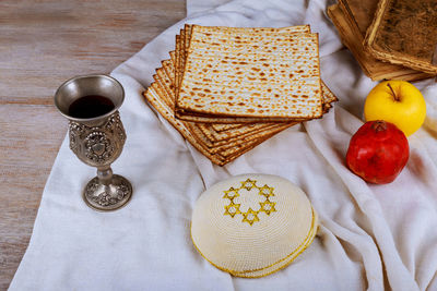 High angle view of matzo with drink and torah on table