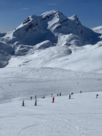 People skiing on snow covered mountain on grindelwald