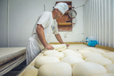 Balkan man rolling out dough at a bakery in belgrade, serbia