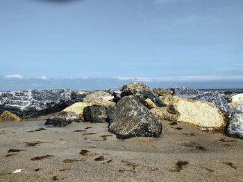 Rocks on beach against sky