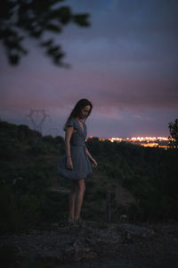 Side view of woman standing on field against sky