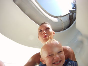 Portrait of happy boy and mother on slide