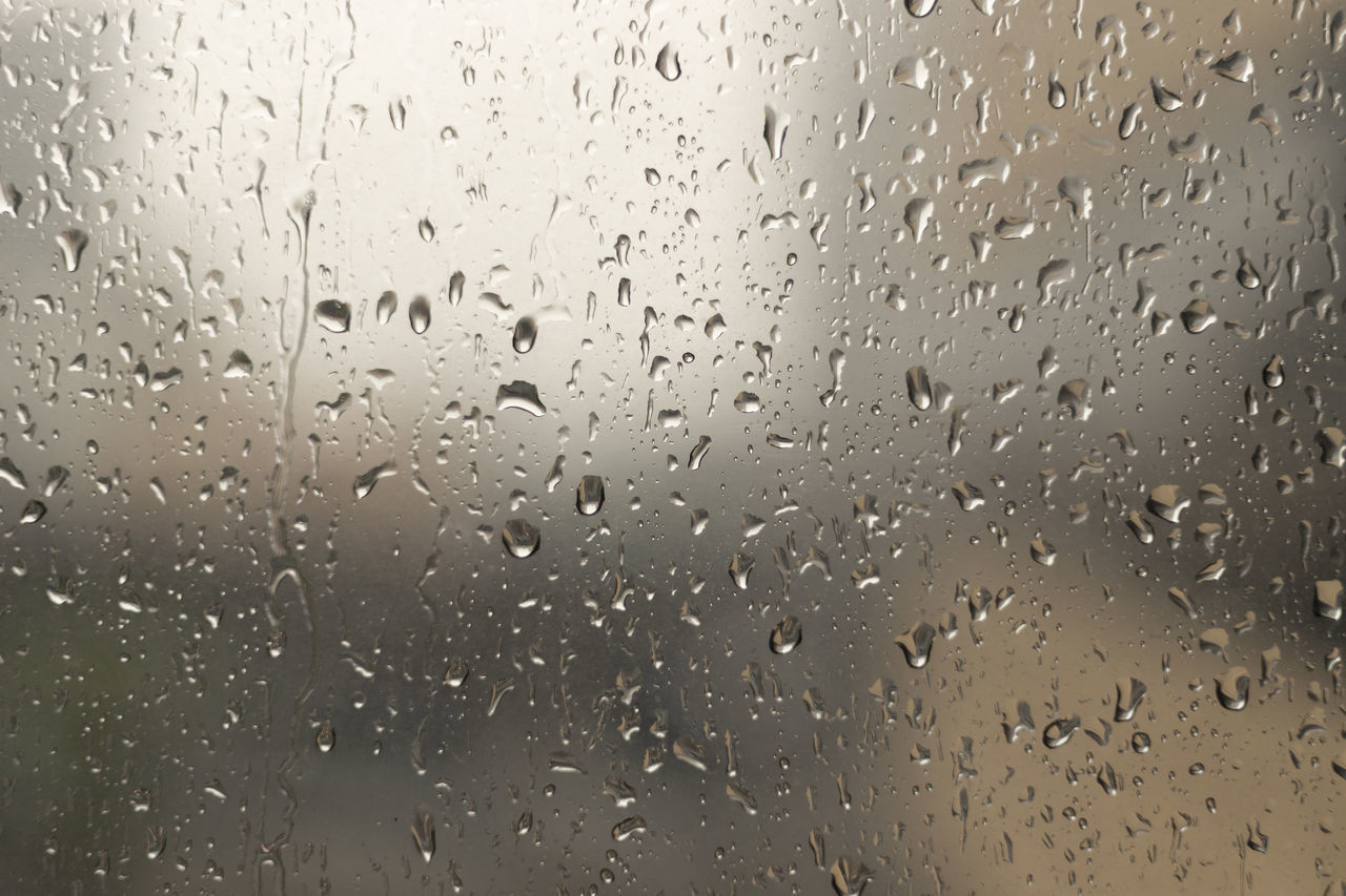FULL FRAME SHOT OF WET GLASS WINDOW IN RAINY SEASON