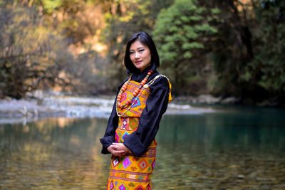 Portrait of young woman standing in lake