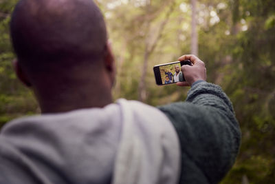 Man taking selfie with family in forest