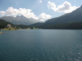 Scenic view of lake by mountains against sky