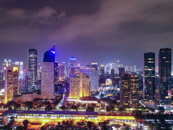 Illuminated buildings in city against sky at night