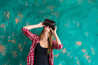 Woman standing outdoors wearing virtual reality headset