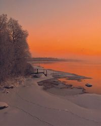 Scenic view of snow covered land during sunset